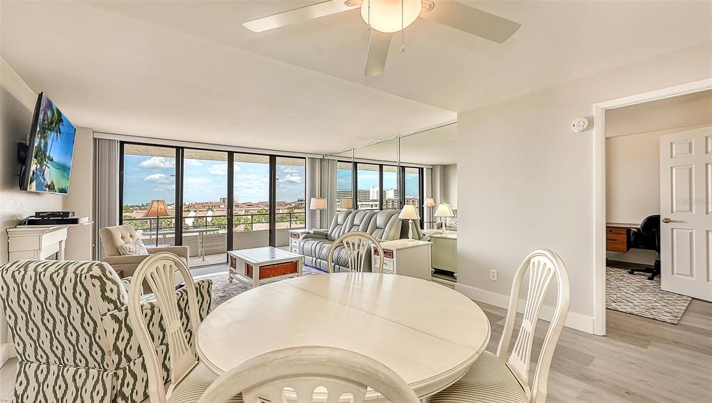 A dining area with a round table opens into a living room featuring floor-to-ceiling windows — 6415 MIDNIGHT PASS ROAD UNIT 602, SARASOTA, FL