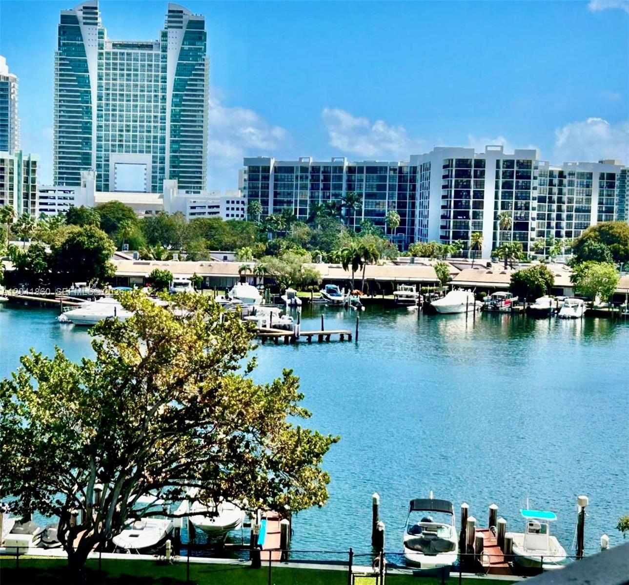 A view of a marina with docked boats in front of high-rise apartment buildings — 500 Three Islands Blvd # 223, Hallandale Beach FL 33009, HALLANDALE BEACH, FL