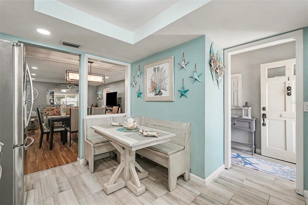 A breakfast nook with a wooden bench table set against a light blue accent wall — 1659 S LAKE AVENUE UNIT 1, CLEARWATER, FL