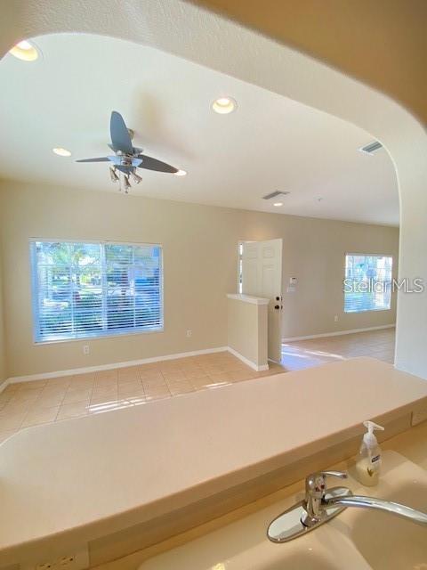 A view from a kitchen sink looking into a living area with tile flooring — 12996 COYOTE LANE, VENICE, FL