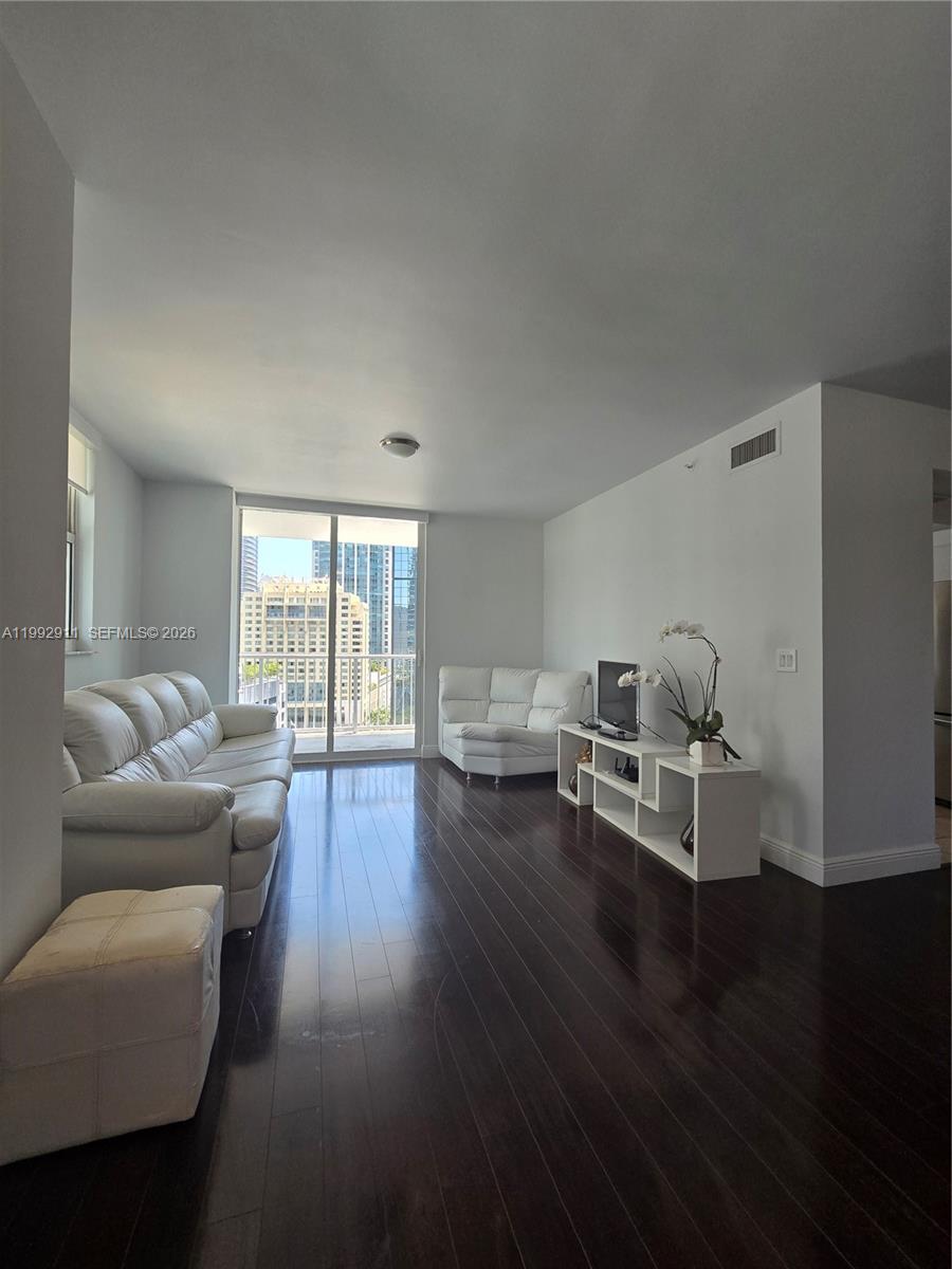 A living room features dark hardwood floors, white leather furniture, and a balcony with city views — 1250 S Miami Ave # 1514, Miami FL 33130, MIAMI, FL