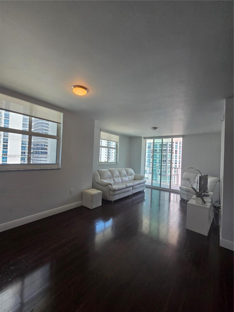 A living room features dark hardwood floors, white leather furniture, and large windows with city views — 1250 S Miami Ave # 1514, Miami FL 33130, MIAMI, FL