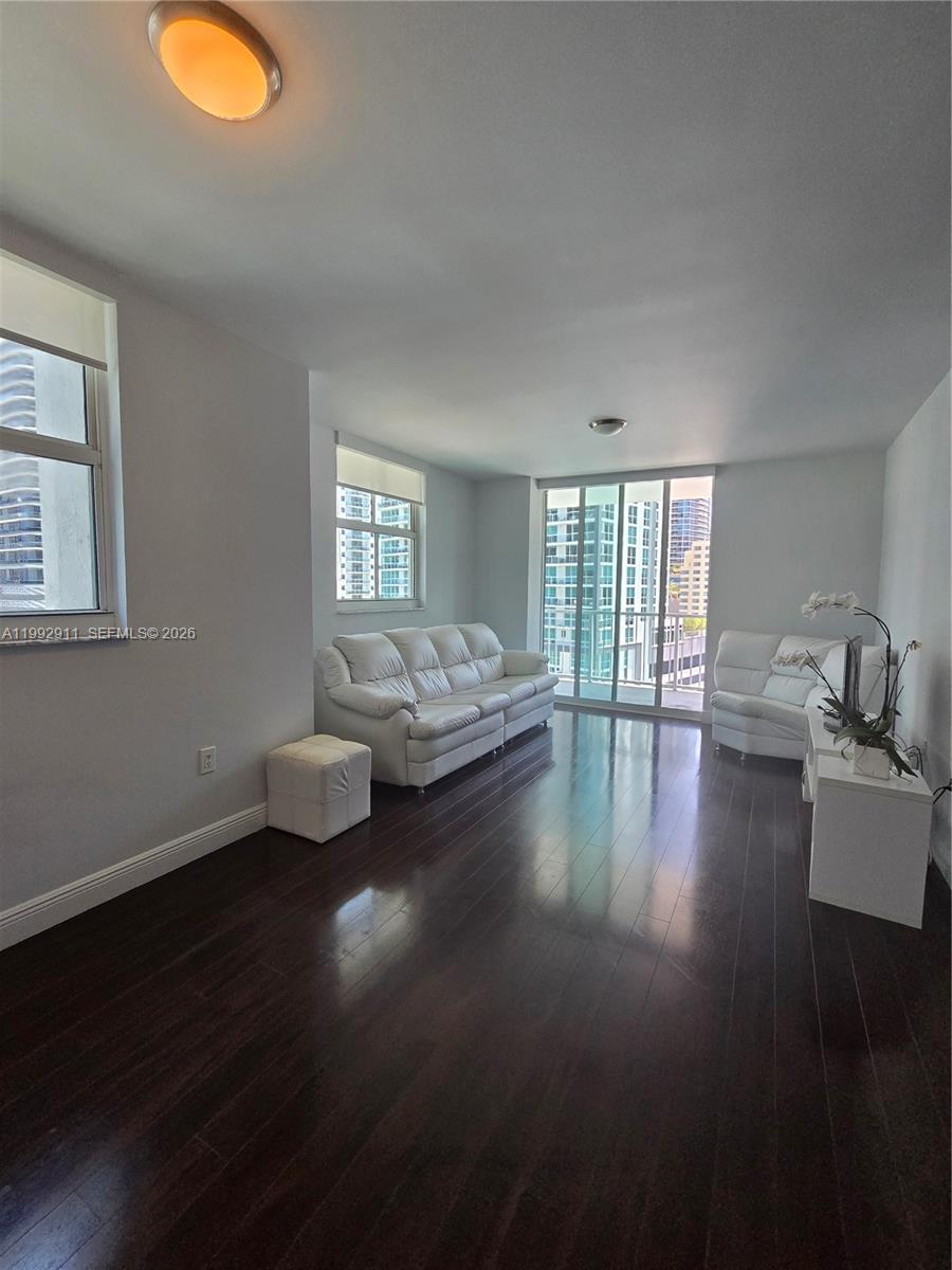 A living room features dark hardwood floors, white leather furniture, and floor-to-ceiling windows — 1250 S Miami Ave # 1514, Miami FL 33130, MIAMI, FL