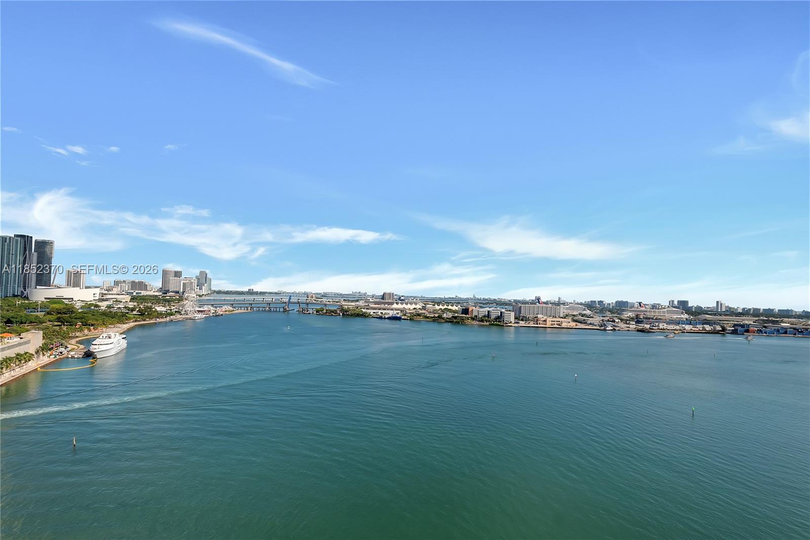 An elevated view of a bay with a city skyline, a bridge, and cruise ships — 848 Brickell Key Dr # 1906, Miami FL 33131, MIAMI, FL
