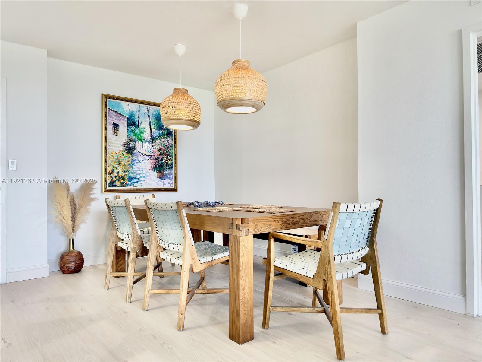 A dining room features a wooden table, woven chairs, and two hanging wicker pendant lights — 3140 S Ocean Dr # 512, Hallandale Beach FL 33009, HALLANDALE BEACH, FL