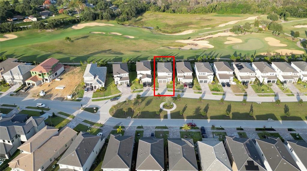 An aerial view shows a residential street with houses bordering a golf course — 15701 VETTA DRIVE, MONTVERDE, FL