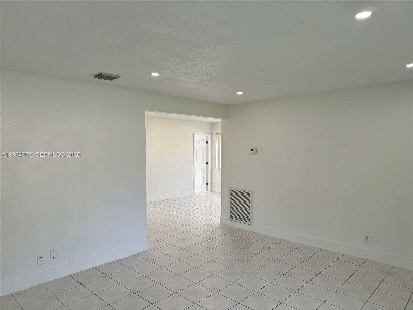 An interior view shows a white-walled room with tiled floors, recessed lighting, and an arched doorway — 2400 N 57th Way, Hollywood FL 33021, HOLLYWOOD, FL