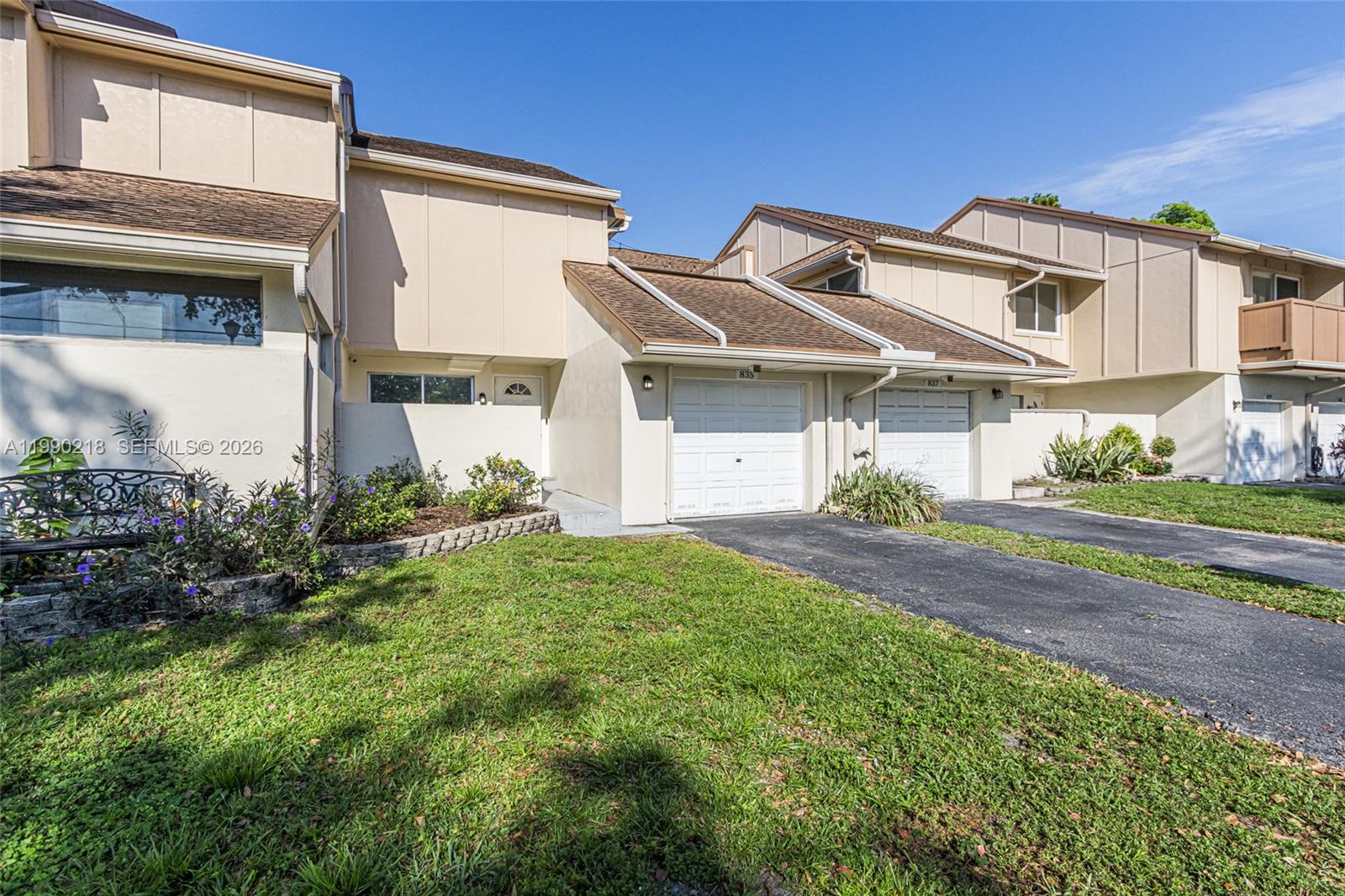 A row of multi-story townhouses features beige stucco siding, brown shingled roofs, and attached garages — 835 NW 80th Ter # 11, Plantation FL 33324, PLANTATION, FL