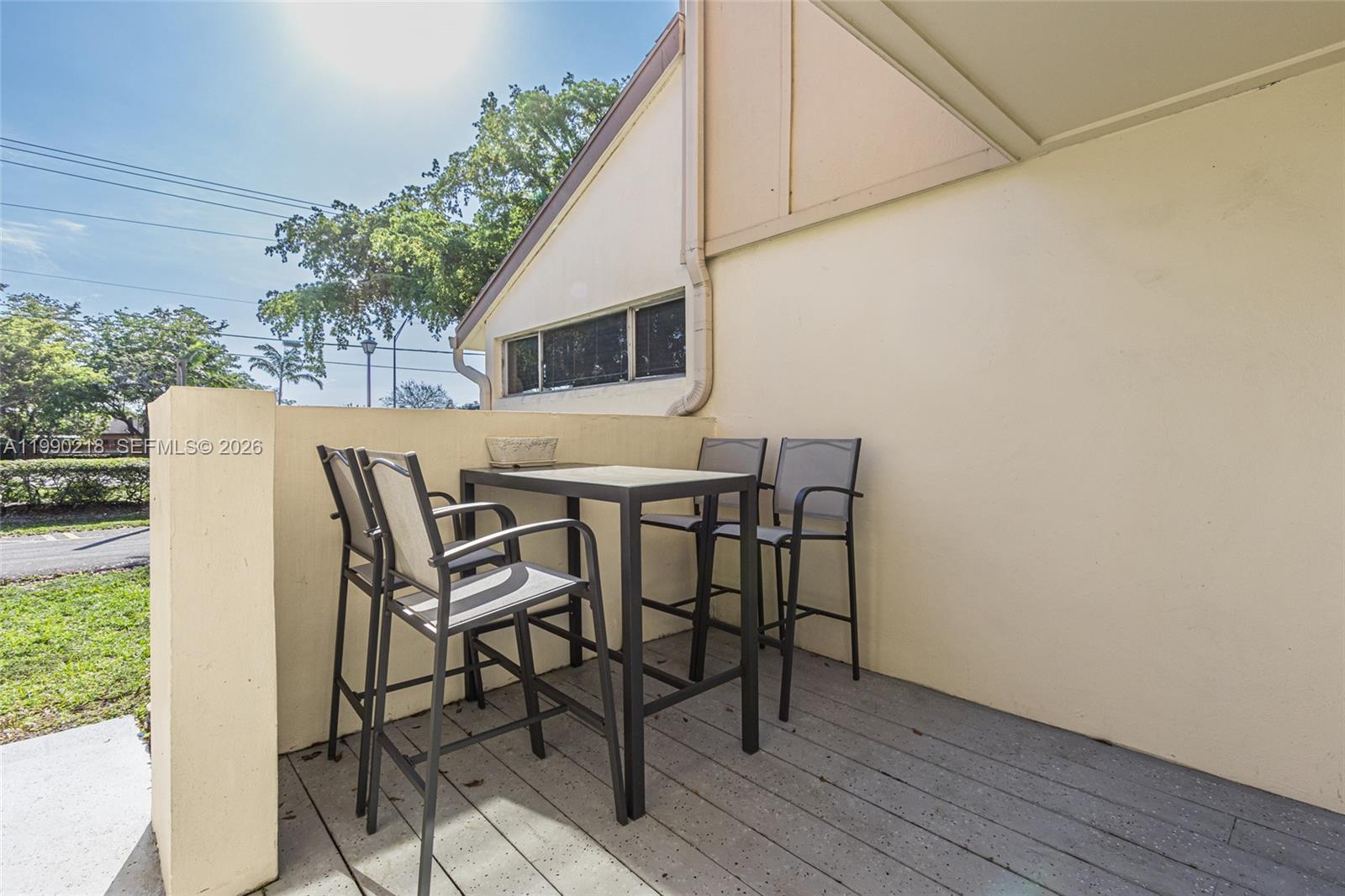A patio features a high-top table with four chairs on a gray wooden deck — 835 NW 80th Ter # 11, Plantation FL 33324, PLANTATION, FL