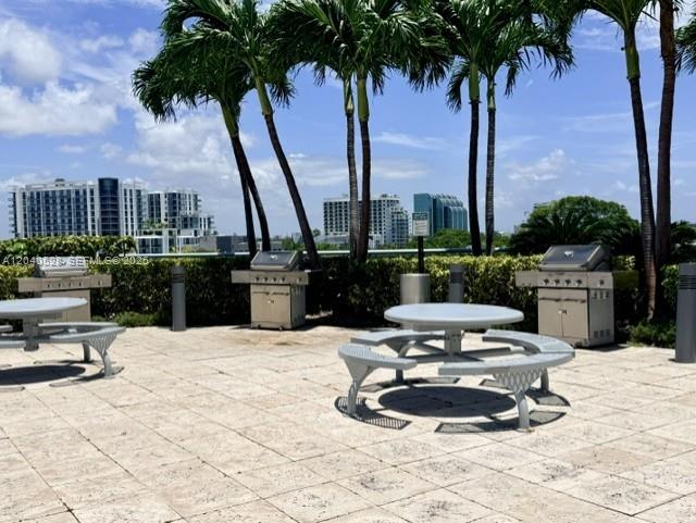An outdoor patio features a picnic table, two stainless steel grills, and several palm trees — 601 NE 36th St # 803, Miami FL 33137, MIAMI, FL