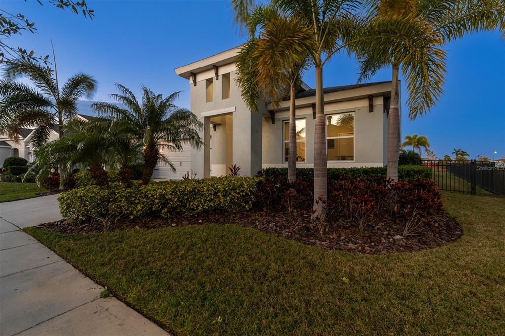 A single-story house with a gray exterior, palm trees, and a landscaped front yard — 5424 SILVER SUN DRIVE, APOLLO BEACH, FL