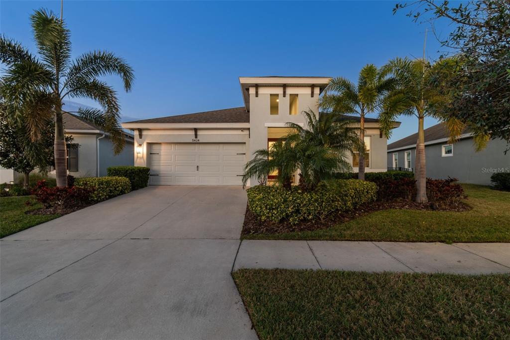 A single-story house with a two-car garage, palm trees, and a concrete driveway — 5424 SILVER SUN DRIVE, APOLLO BEACH, FL
