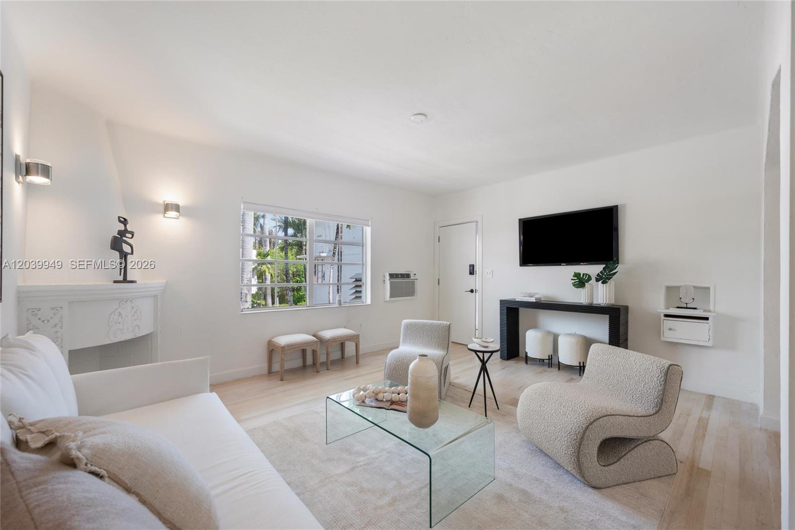 A bright living room features white walls, a glass coffee table, and modern textured chairs — 750 Espanola Way # 8, Miami Beach FL 33139, MIAMI BEACH, FL