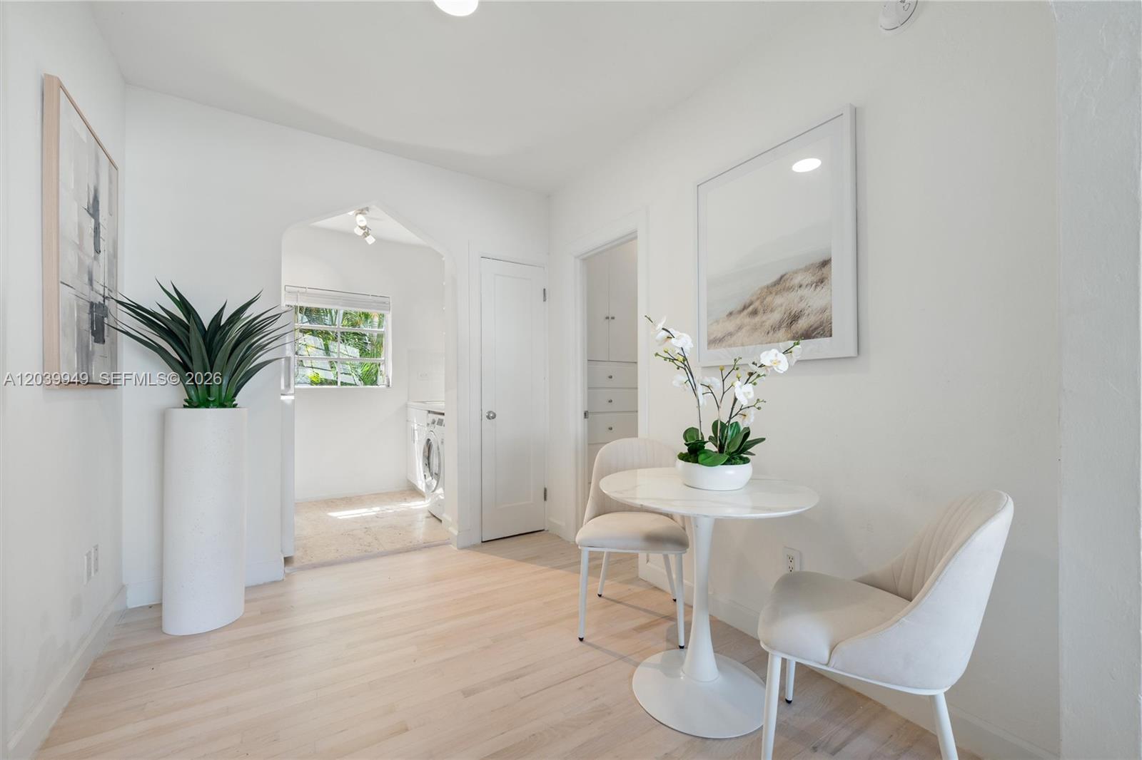 A bright dining area features a small round table, two chairs, and a laundry room — 750 Espanola Way # 8, Miami Beach FL 33139, MIAMI BEACH, FL