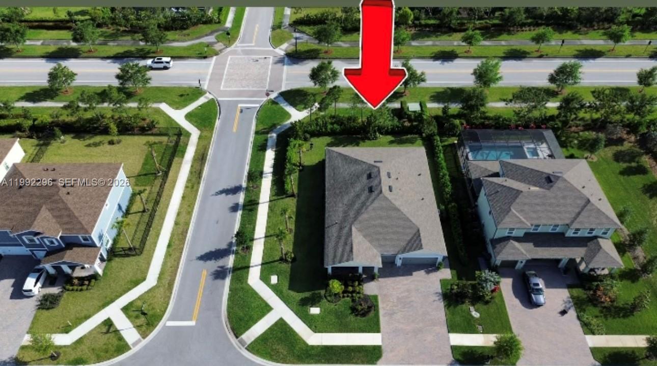 An aerial view shows a suburban house with a paved driveway and a backyard hedge — 19148 N Broad Shore Walk, Loxahatchee FL 33470, LOXAHATCHEE, FL