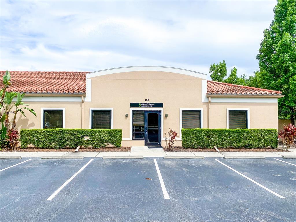 A single-story commercial building with a tiled roof and a parking lot in front — 3911 GOLF PARK LOOP UNIT 105, BRADENTON, FL