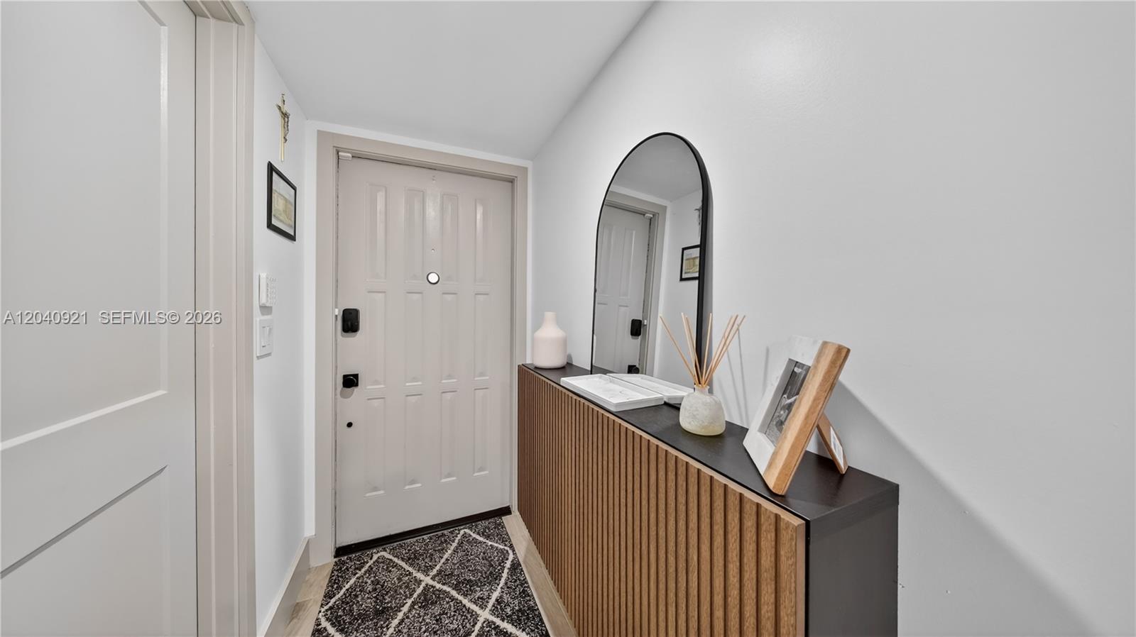 An entryway features a light-colored door, a slatted console table, and an arched wall mirror — 8046 SW 21st Ct, Davie FL 33324, DAVIE, FL