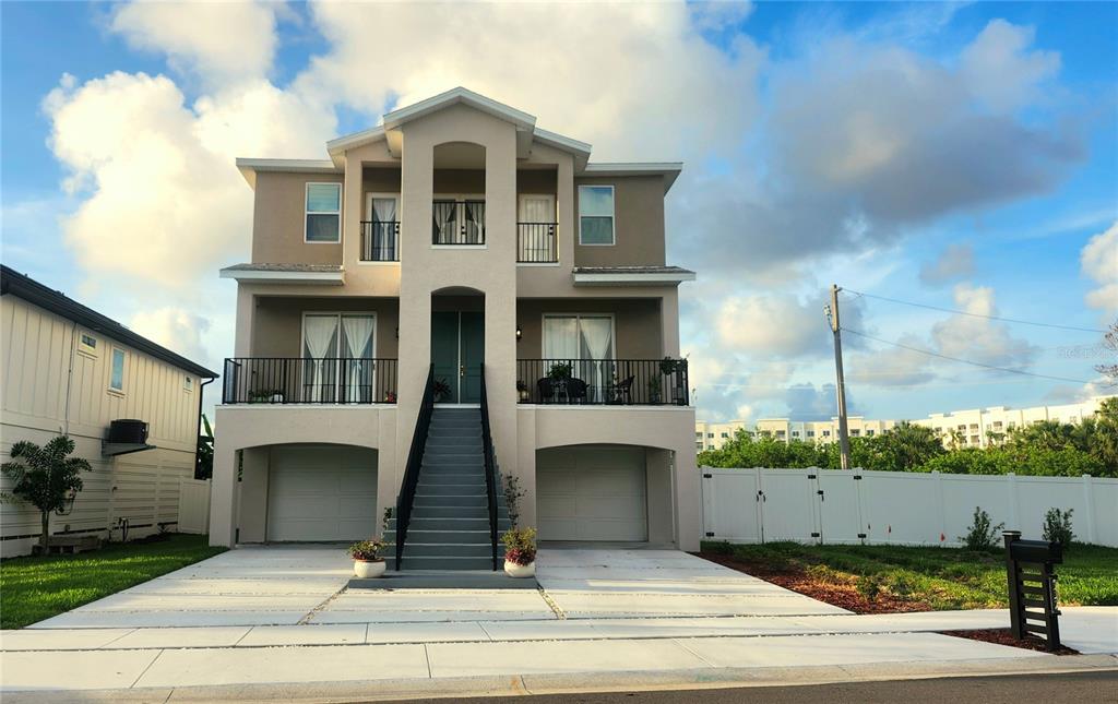 A three-story house with a central staircase, two garages, and balconies on the upper levels — 5324 JOBETH DRIVE, NEW PORT RICHEY, FL