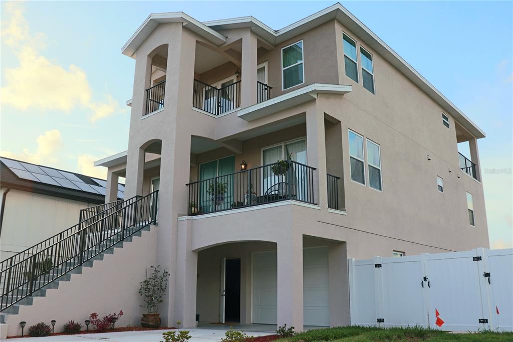 A three-story house with a raised entrance, balconies, and a ground-level garage — 5324 JOBETH DRIVE, NEW PORT RICHEY, FL