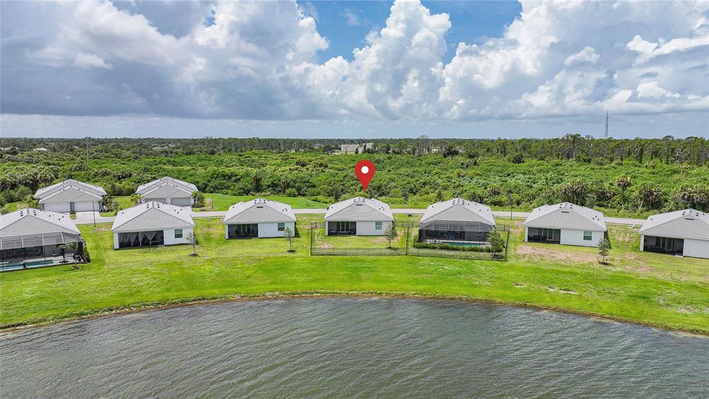 An aerial view shows a row of suburban houses along a lake with a red pin — 8268 SHORE LAKE DRIVE, ENGLEWOOD, FL