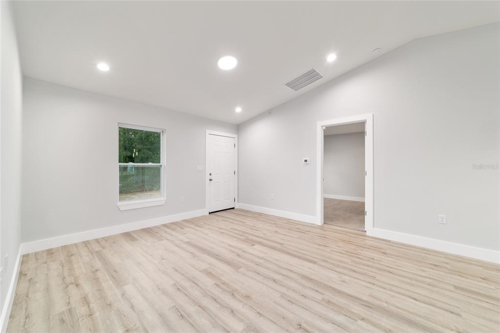 A gray single-story house with a white garage door and a concrete driveway — 15342 SW 38TH PLACE, OCALA, FL