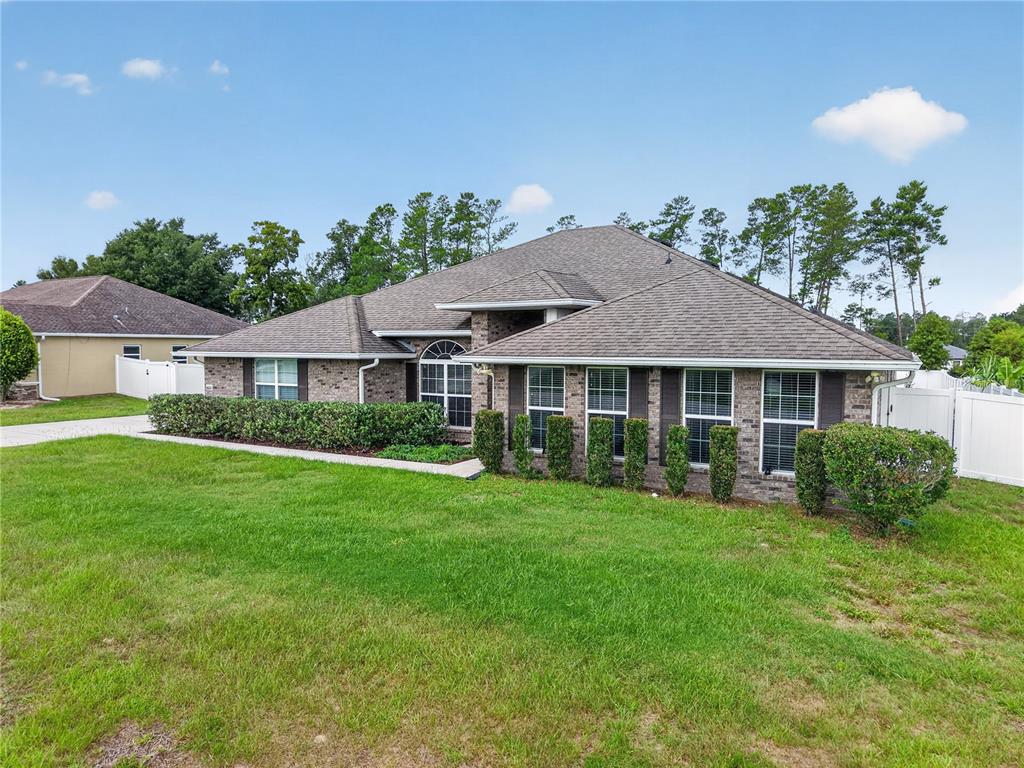A single-story brick house with a shingled roof and a manicured lawn — 9636 SW 40TH TERRACE, OCALA, FL