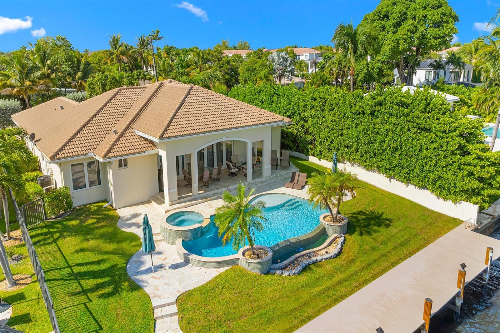 An aerial view of a house with a tiled roof, swimming pool, and private dock — 3219 Karen Drive, Delray Beach FL 33483, DELRAY BEACH, FL