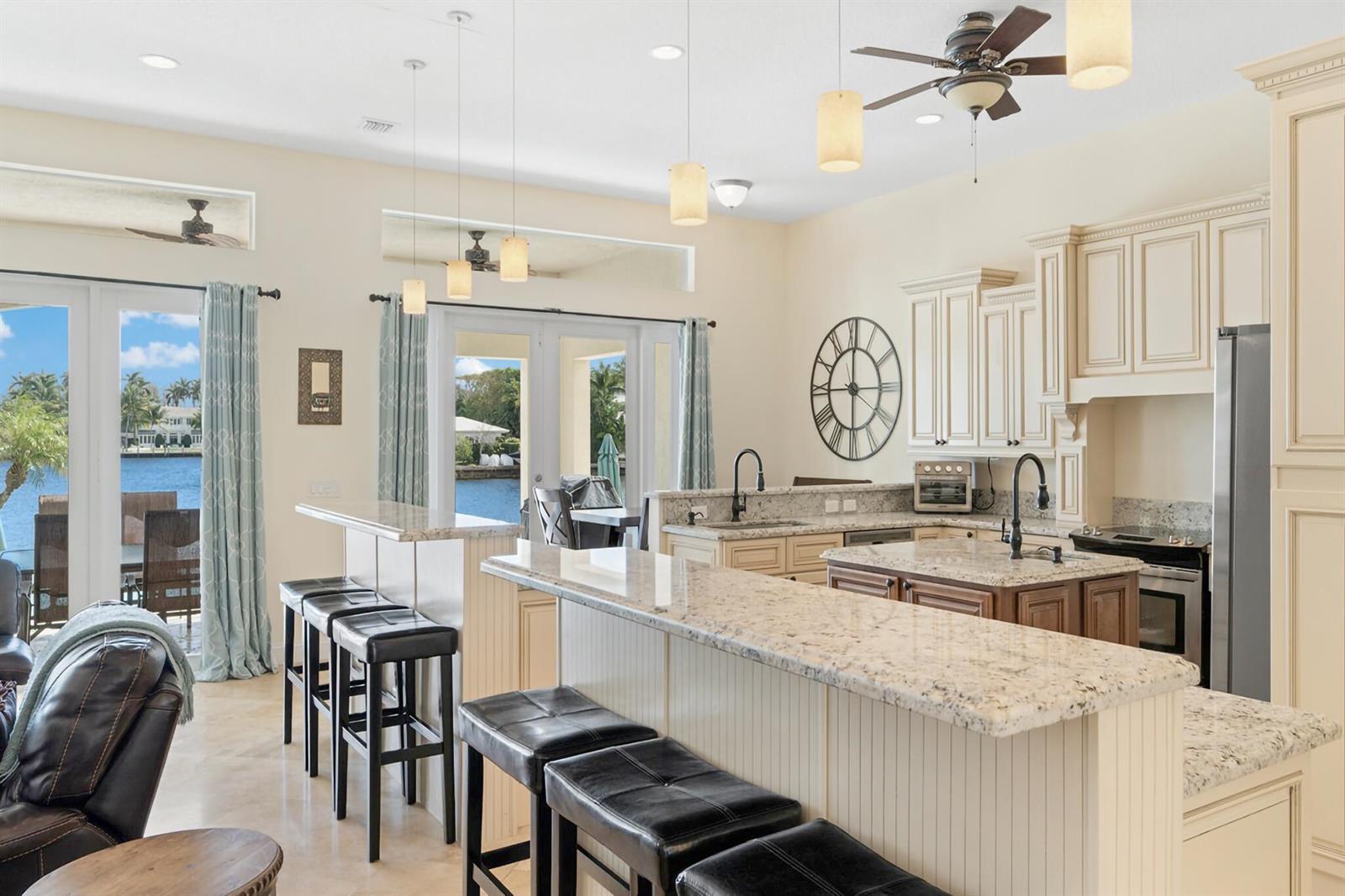 A kitchen with granite countertops, a breakfast bar, and a view of the water outside — 3219 Karen Drive, Delray Beach FL 33483, DELRAY BEACH, FL