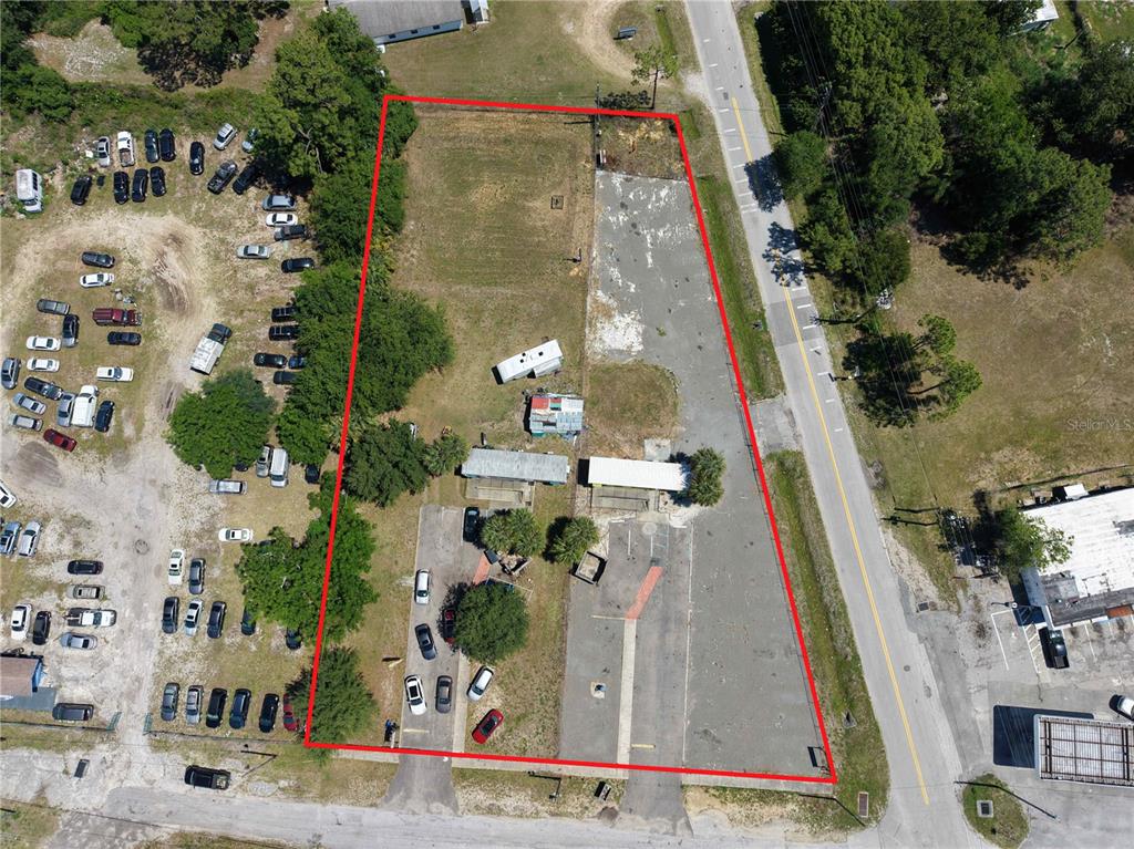 An aerial view shows a trapezoidal lot with paved areas, structures, and surrounding vehicles — 17925 OLD CHENEY HWY, ORLANDO, FL