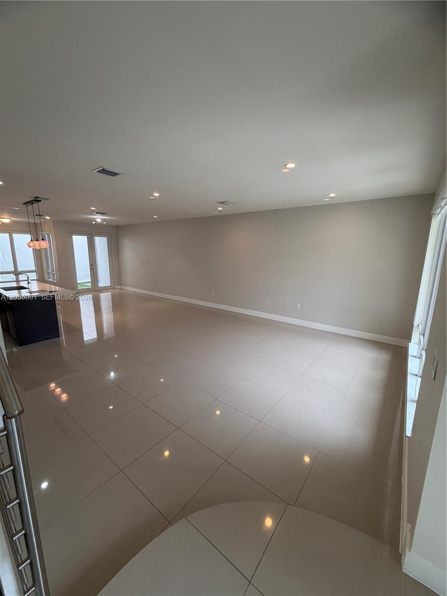 A spacious, open-concept living area features light-colored tile flooring and recessed ceiling lighting — 6440 NW 103rd Psge # 6440, Doral FL 33178, DORAL, FL