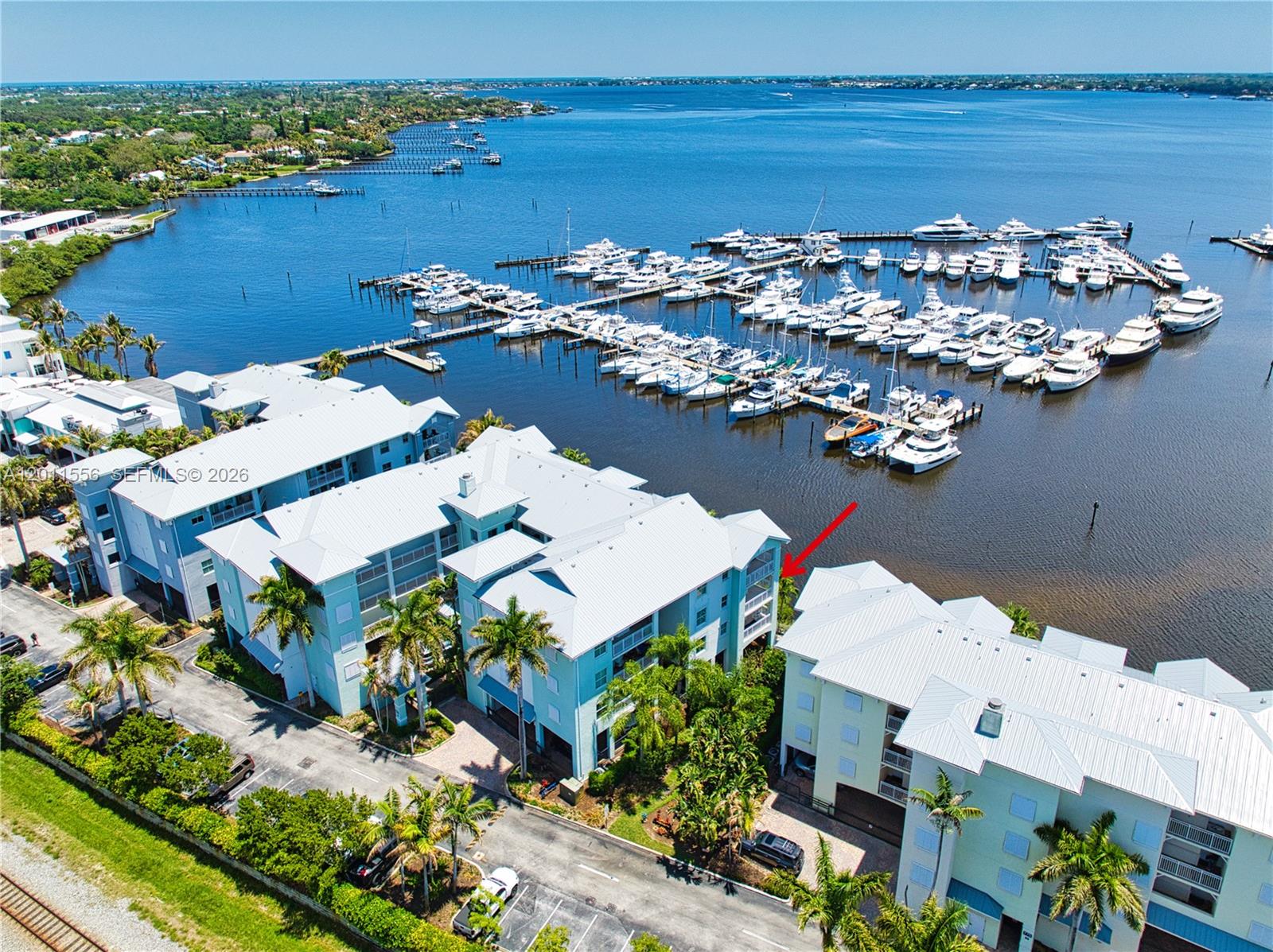 An aerial view shows multi-story waterfront residential buildings adjacent to a large boat marina — 815 NW Flagler Ave # 305, Stuart FL 34994, STUART, FL