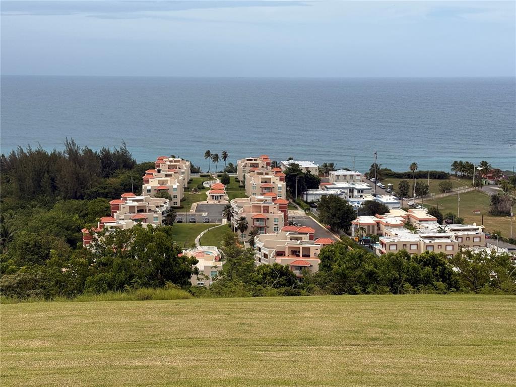 An elevated view of a coastal residential complex with multiple buildings overlooking the ocean — 665 AQUAMARINA, ISABELA, PR