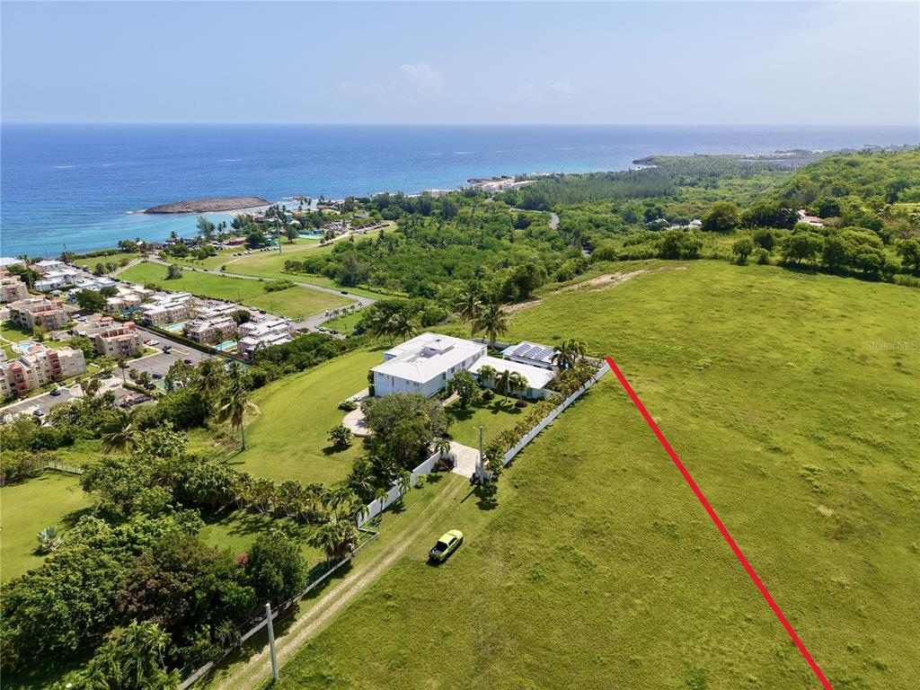 An aerial view shows a white house with a metal roof and solar panels — 665 AQUAMARINA, ISABELA, PR