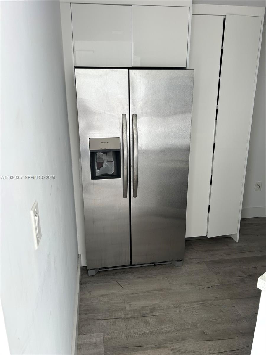 A stainless steel side-by-side refrigerator is set between white cabinets and a tall pantry — 6921 Environ Blvd # 7P, Lauderhill FL 33319, LAUDERHILL, FL