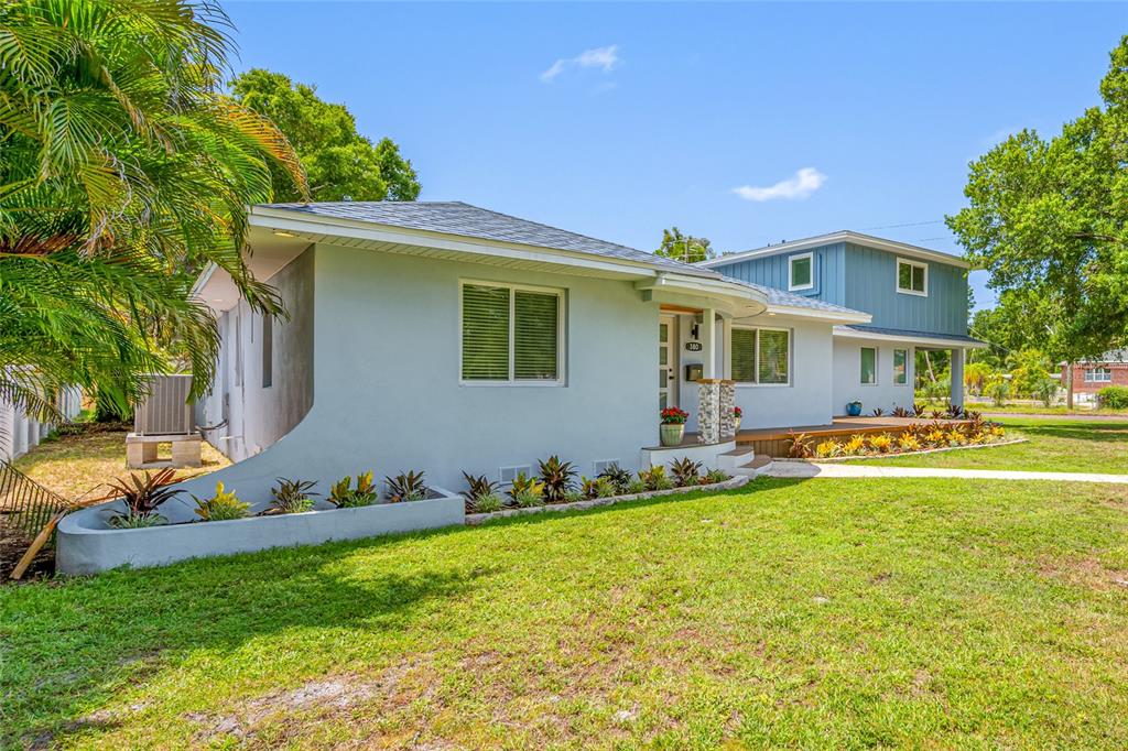 A light blue, single-story house with a curved front wall and a two-story addition — 380 VILLAGRANDE AVENUE S, ST PETERSBURG, FL