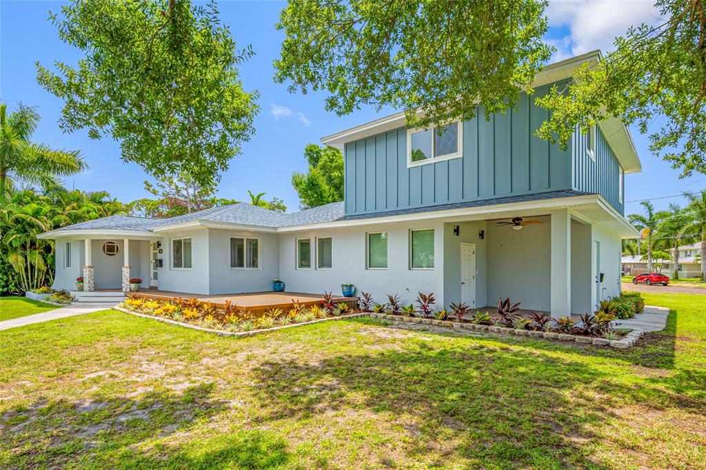 A two-story house with blue vertical siding and a gray ground floor features a deck — 380 VILLAGRANDE AVENUE S, ST PETERSBURG, FL