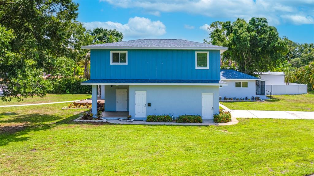 A two-story house with blue vertical siding on top and light blue stucco below — 380 VILLAGRANDE AVENUE S, ST PETERSBURG, FL