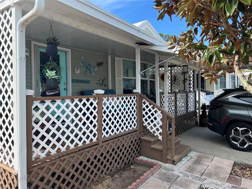A landscaped yard features gravel, potted plants, garden gnomes, and pink flamingo statues — 443 PANSY STREET, DAVENPORT, FL
