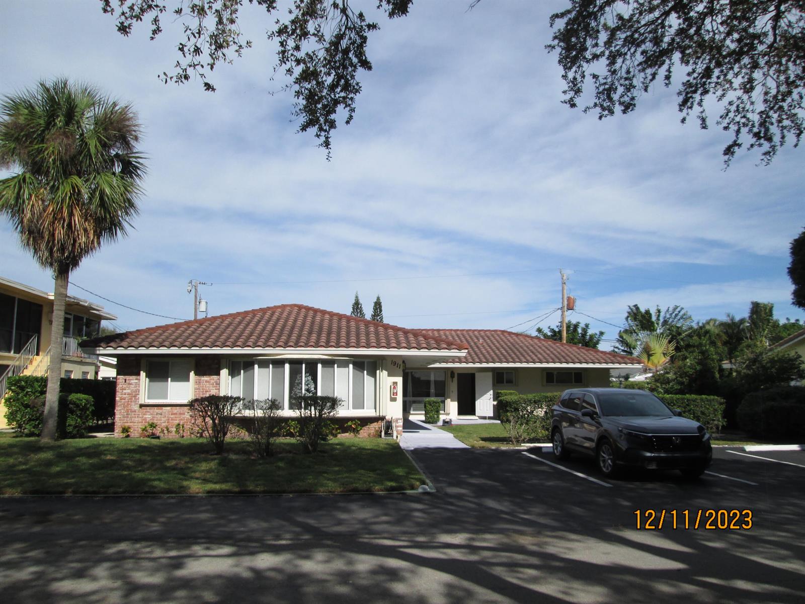 A single-story house with a tiled roof, brick accents, and a driveway with a parked car — 1911 NE 27th Court # 3, Lighthouse Point FL 33064, LIGHTHOUSE POINT, FL