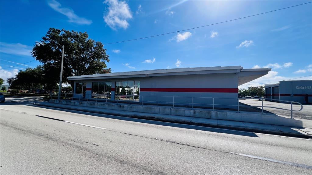 A single-story commercial building with a gray exterior and a red horizontal stripe — 2010 8TH STREET NW, WINTER HAVEN, FL