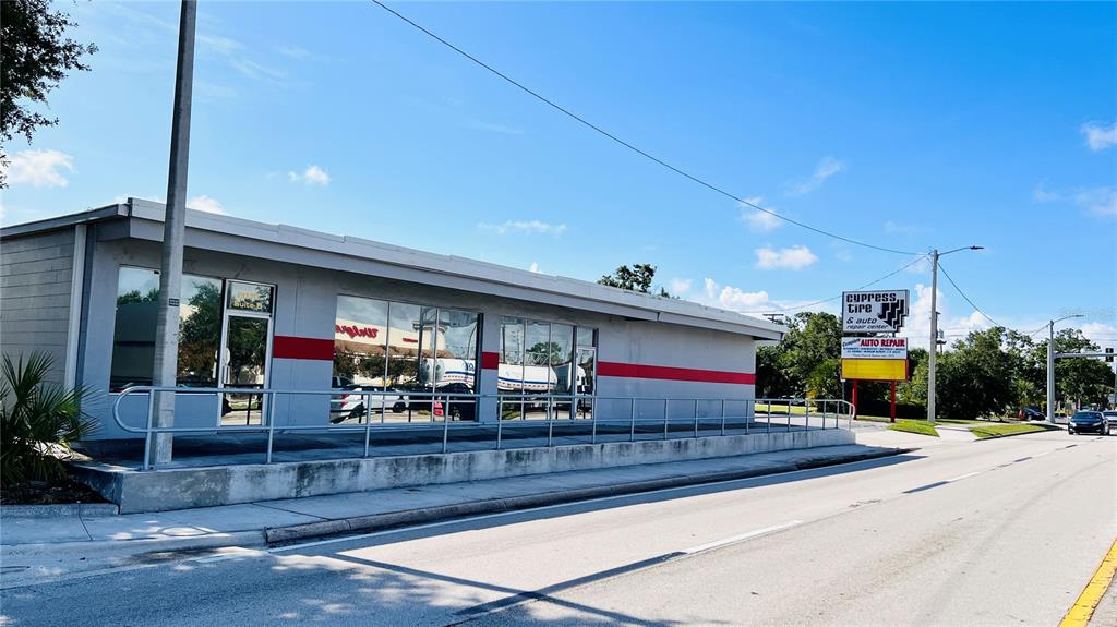 A single-story commercial building with a red stripe and a roadside sign for auto repair — 2010 8TH STREET NW, WINTER HAVEN, FL