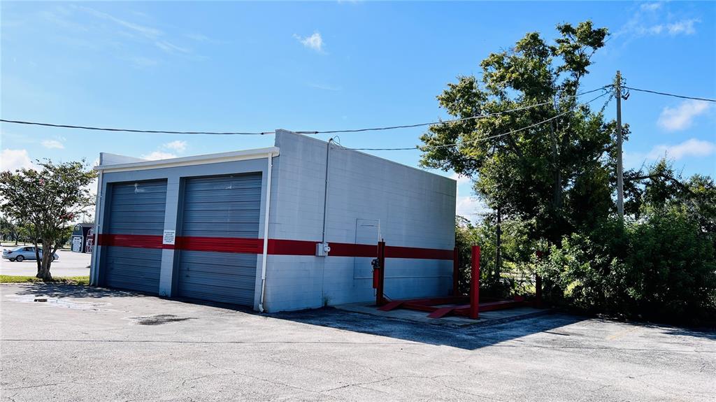 A gray concrete building with two garage doors and an outdoor car lift — 2010 8TH STREET NW, WINTER HAVEN, FL