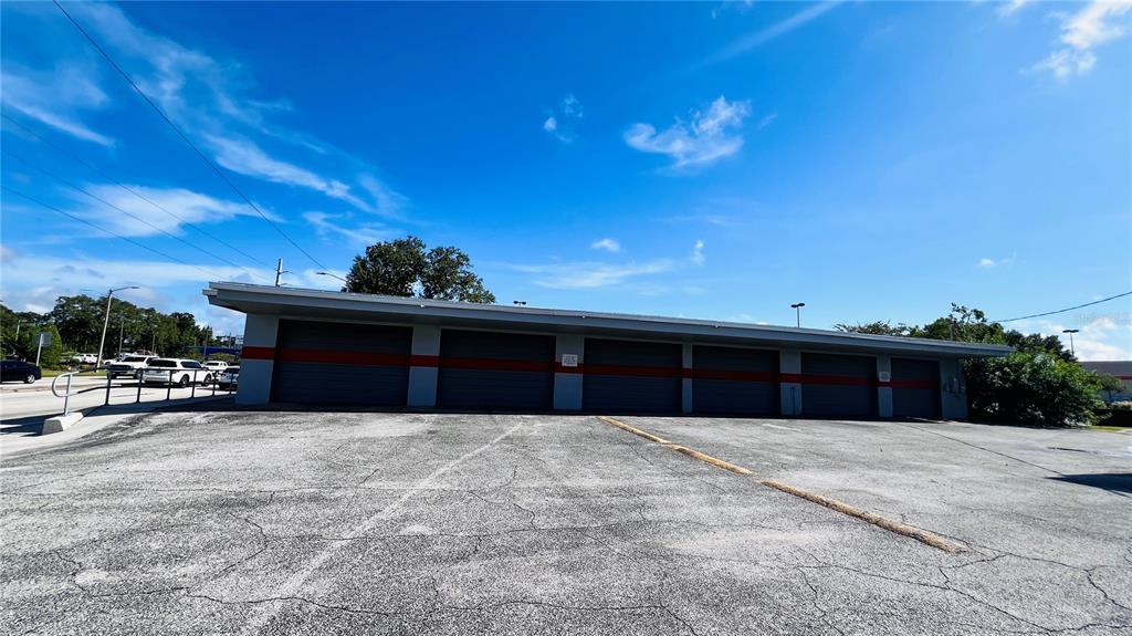 A single-story commercial building with multiple garage bays sits next to an asphalt parking lot — 2010 8TH STREET NW, WINTER HAVEN, FL