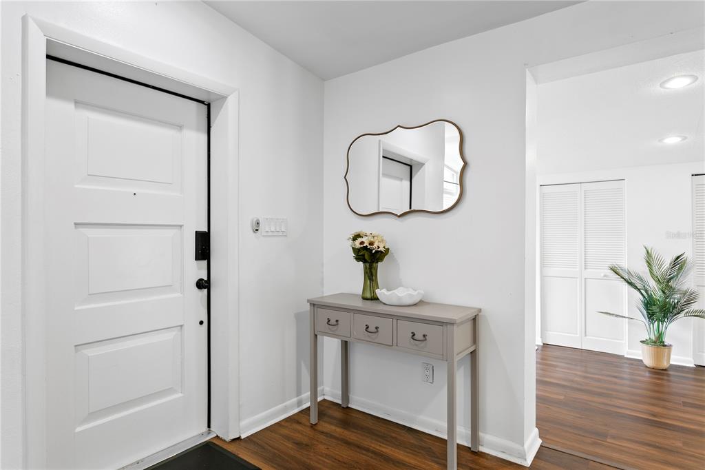 A single-story gray house with a brick entryway, large windows, and a concrete driveway — 2407 S LOIS AVENUE, TAMPA, FL