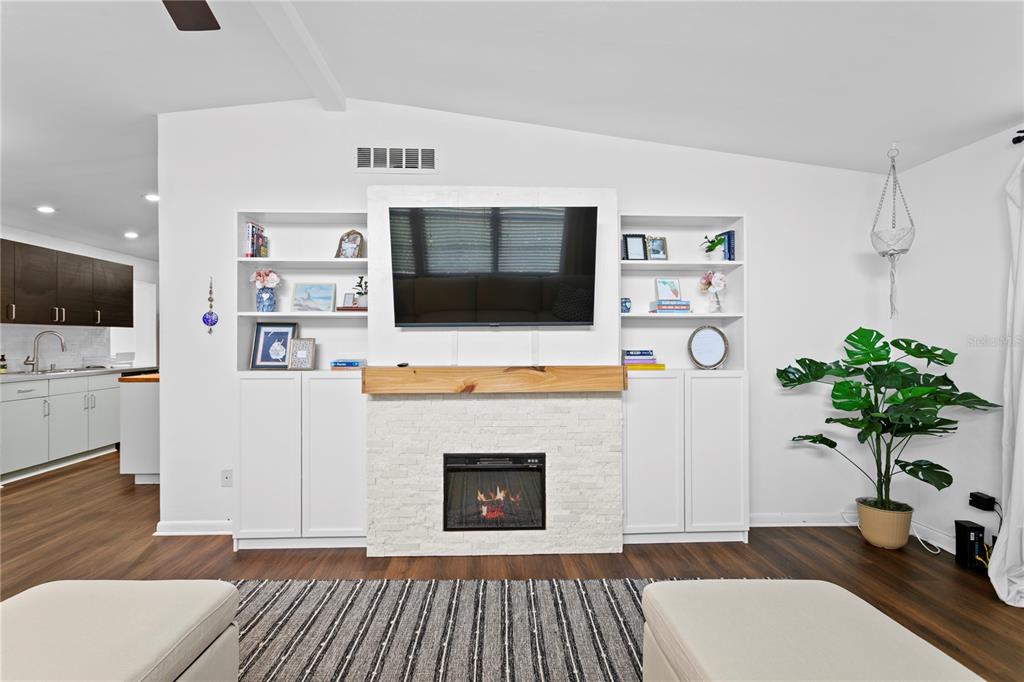 A living room features a white sectional sofa, a fireplace, and a ceiling fan — 2407 S LOIS AVENUE, TAMPA, FL