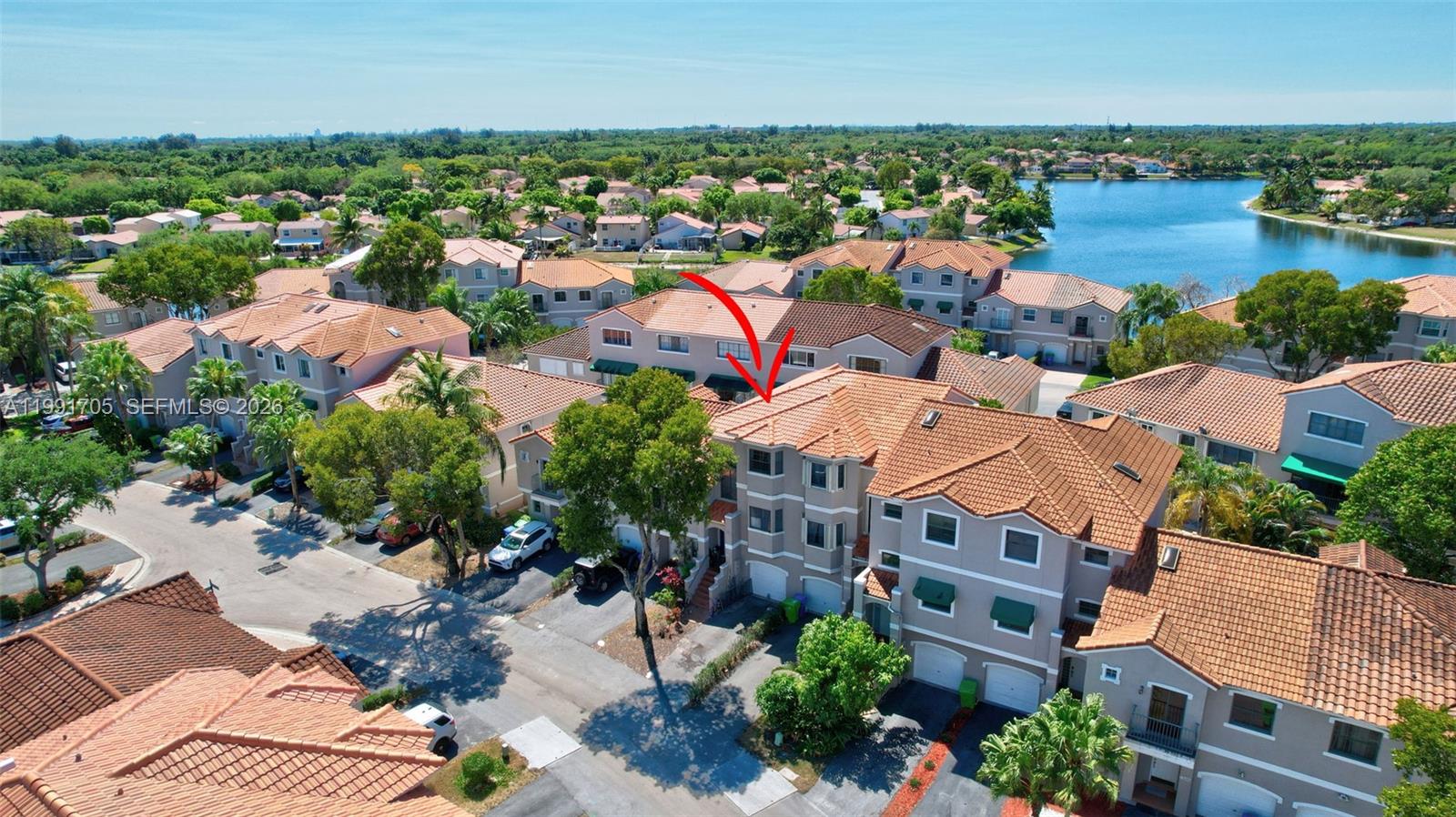 An aerial view shows a multi-story townhouse complex with terracotta tile roofs and driveways — 12662 NW 14th St, Sunrise FL 33323, SUNRISE, FL