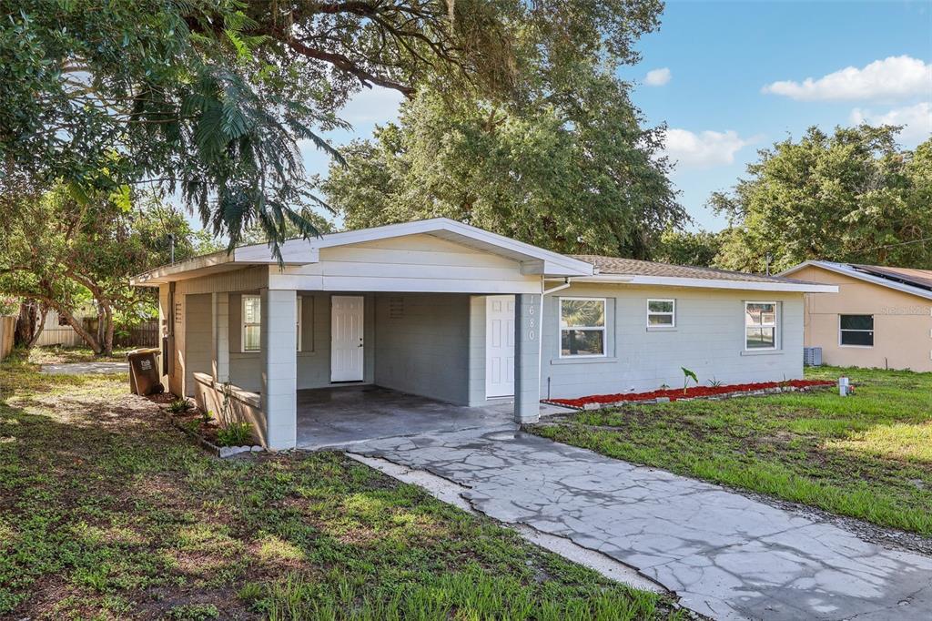 A single-story house with a gray exterior, a front carport, and a concrete driveway — 1680 32ND STREET NW, WINTER HAVEN, FL