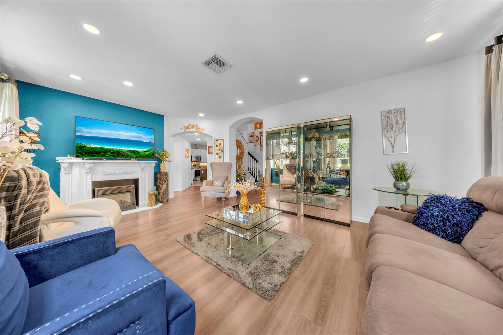 A living room features a blue accent wall with a fireplace, television, and light flooring — 726 Gazetta Way, West Palm Beach FL 33413, WEST PALM BEACH, FL