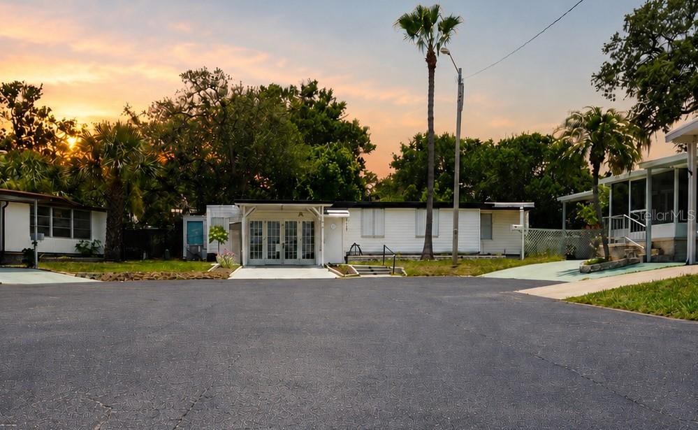 A white mobile home with a covered entrance sits at the end of a paved driveway — 980 7TH STREET NW UNIT 71, LARGO, FL