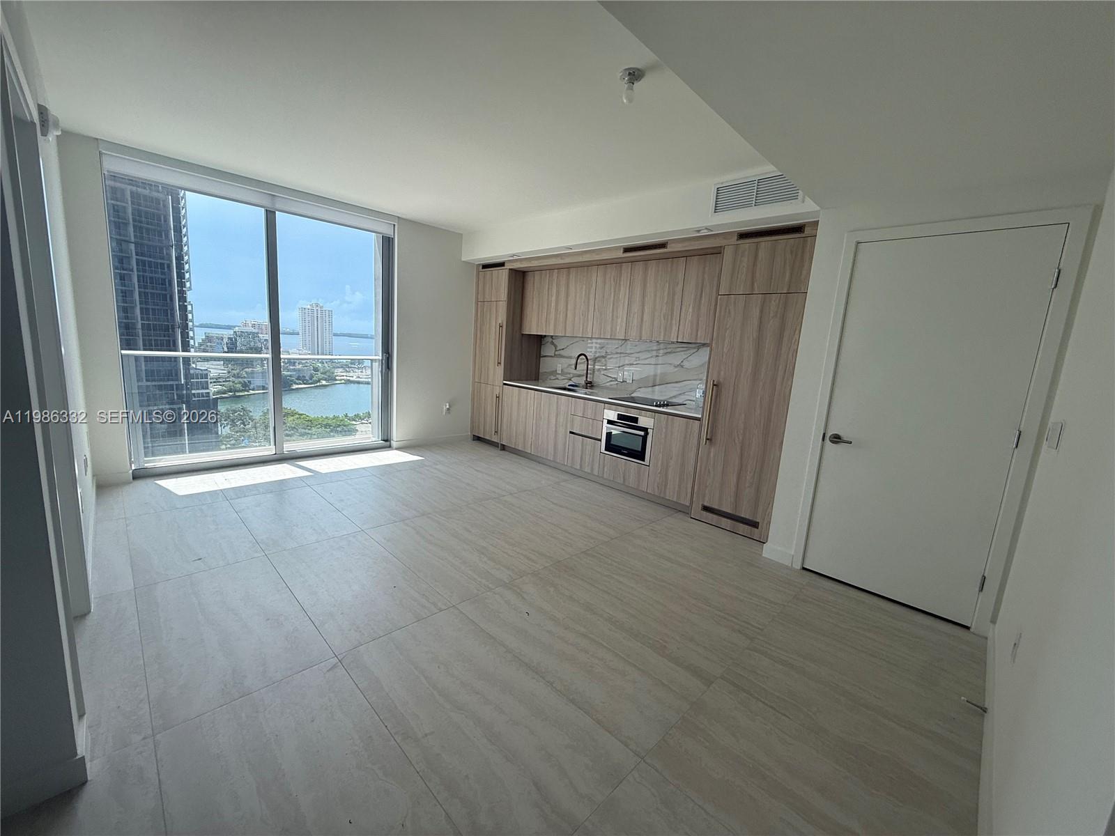 An elevated view of a turquoise waterway, luxury yachts, modern high-rise buildings, and a park — 77 SE 5 St # 2015, Miami FL 33131, MIAMI, FL